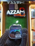 Lens shield packaging held in front of an Azzam Store sign