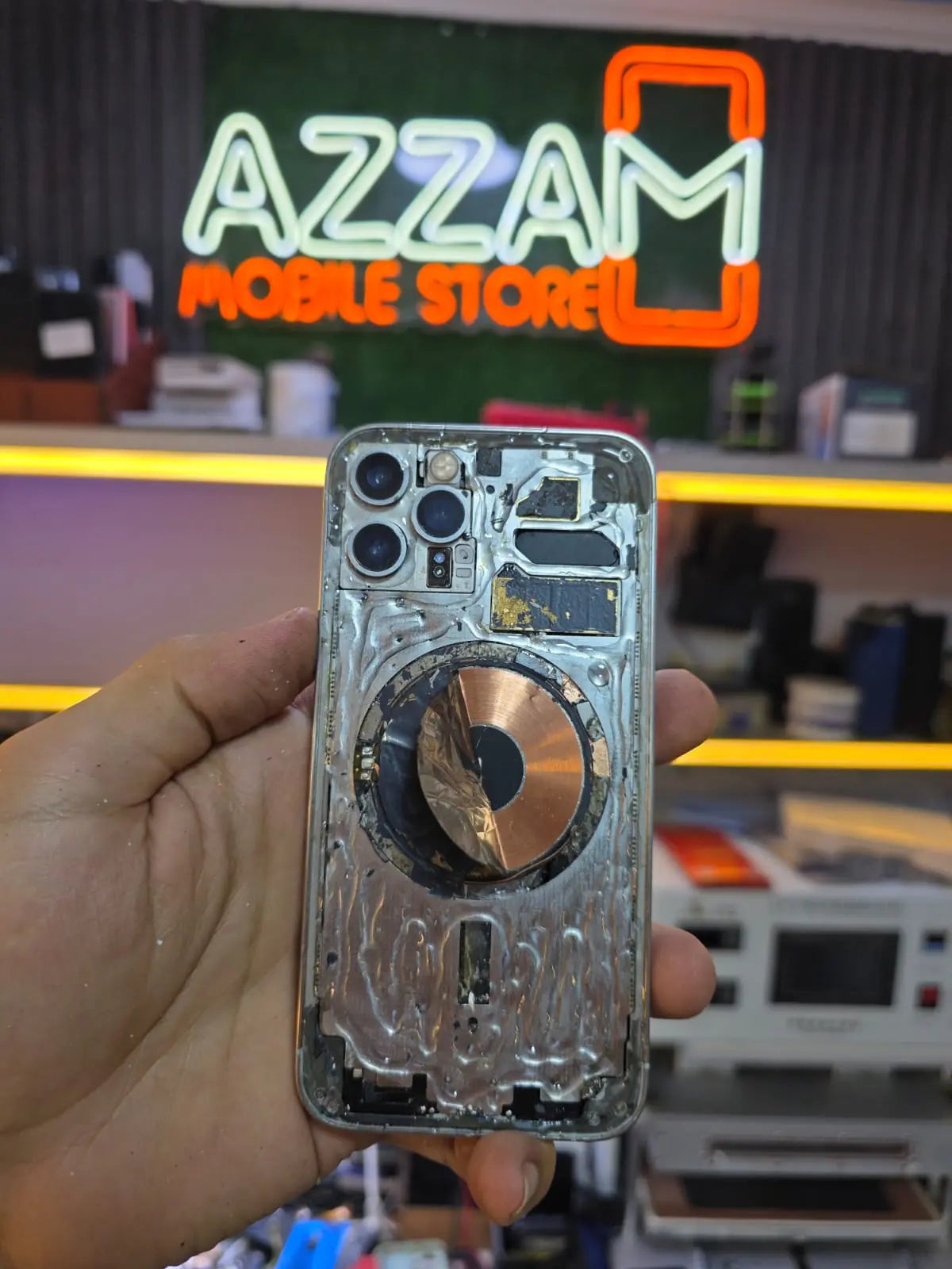 A damaged iPhone with a severely cracked and shattered screen, displaying detailed glass fractures before repair.